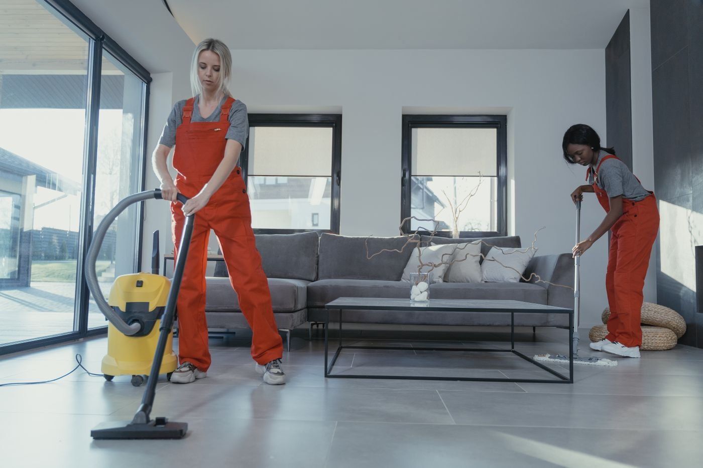 İki kişilik ekip salonda ekstraksiyon makinesiyle çalışırken